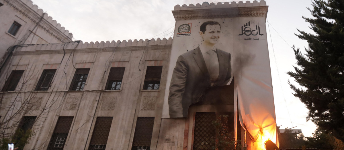 Los insurgentes prenden fuego a un cartel de Al Asad tras la toma de Hama