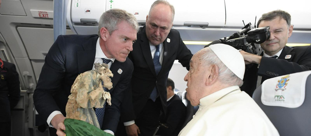 Matteo Bruni, director de la oficina de prensa del Vaticano, entrega al Papa la escultura en el vuelo a Córcega