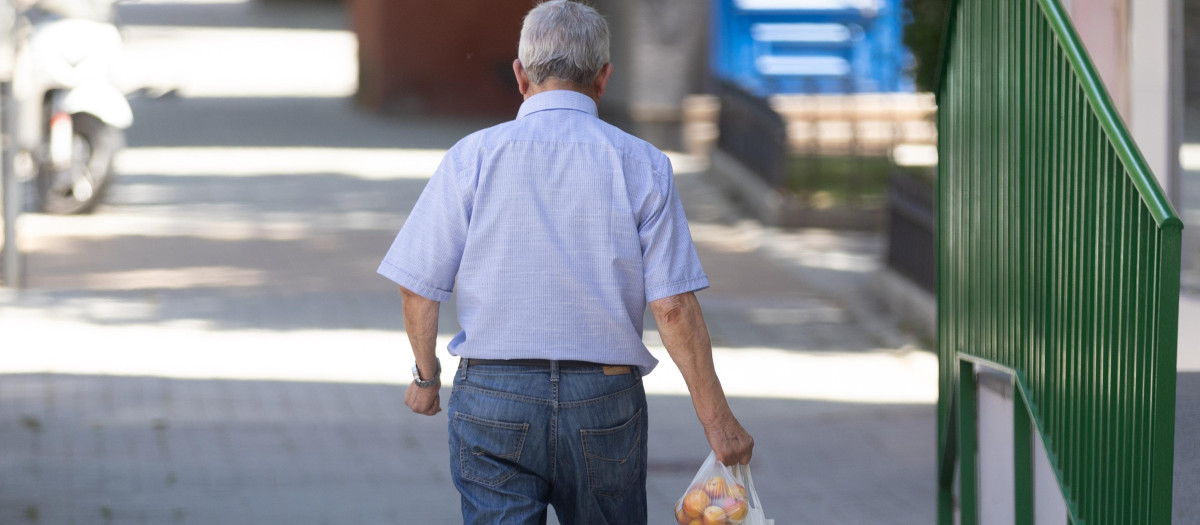 Un señor mayor camina con la compra