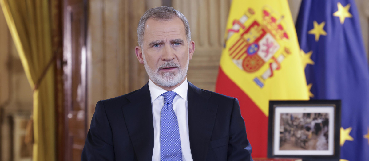 El Rey, flanqueado por las banderas de España y la UE