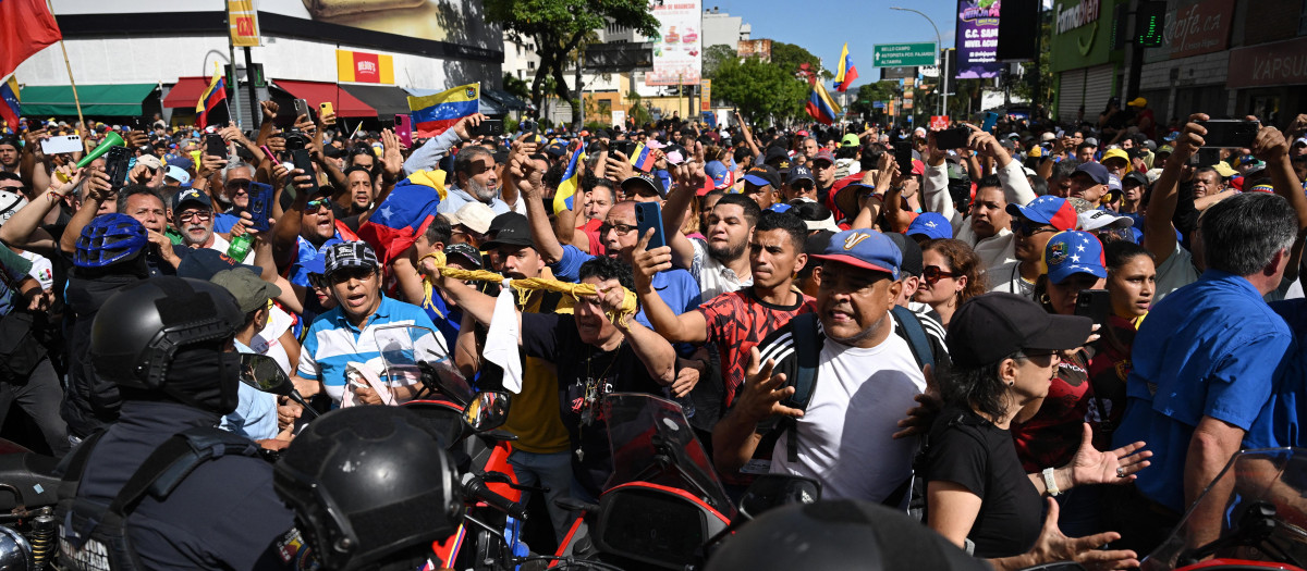 Manifestantes bloquean a miembros de la policía después de que la líder opositora venezolana María Corina Machado pronunciara un discurso durante la protesta convocada por la oposición en Caracas