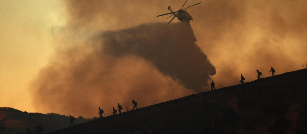 Un helicóptero arroja agua sobre el incendio forestal Kenneth en el barrio de Woodland Hills en Los Ángeles