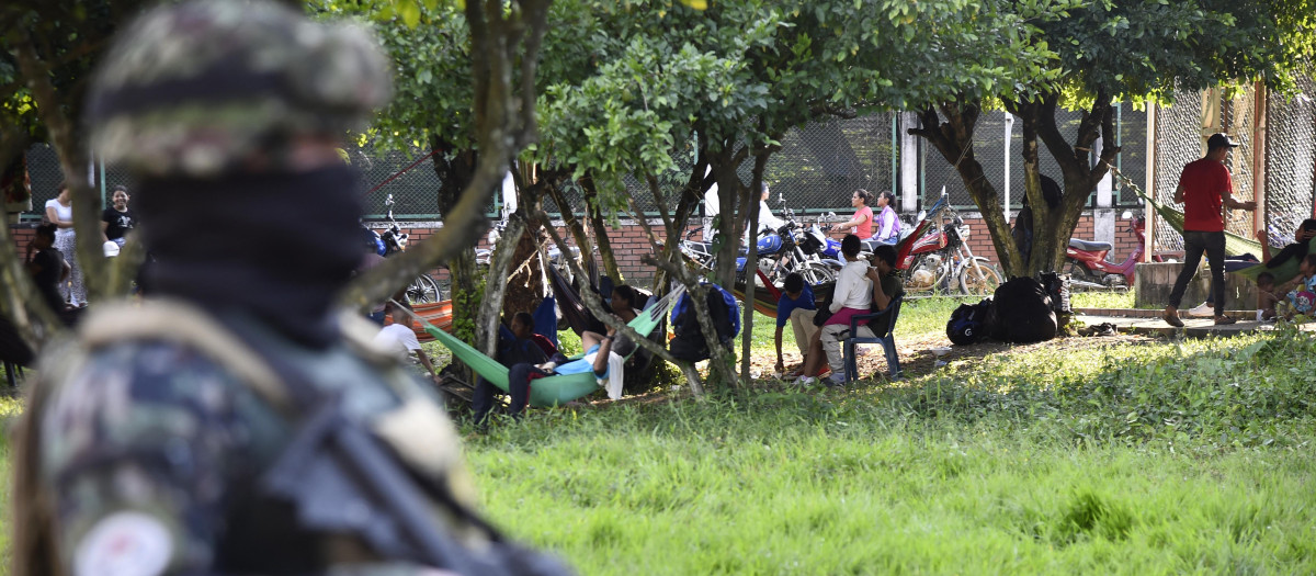 Soldados del ejército colombiano hacen guardia junto a personas desplazadas por los recientes enfrentamientos entre grupos armados que llegaron al municipio de Tibú,