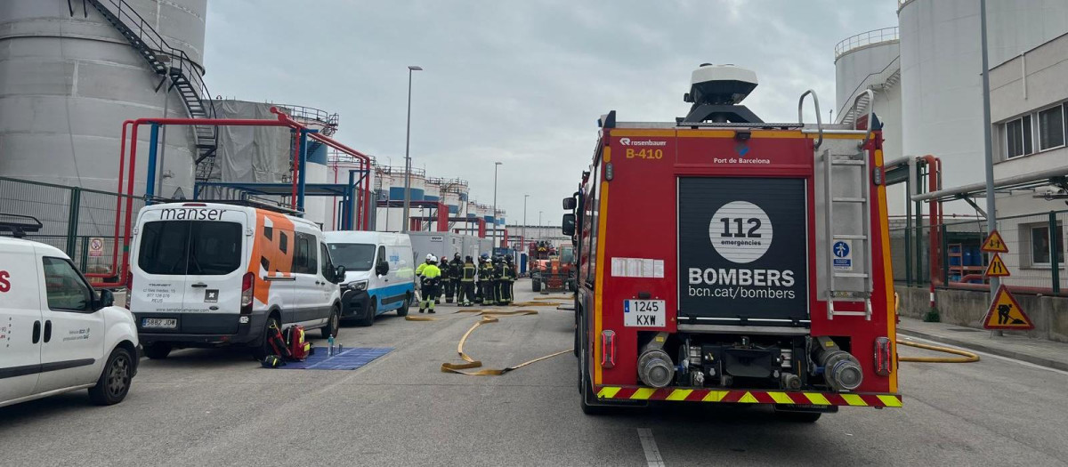 Los bomberos trabajando en apagar el fuego declarado en el puerto de Barcelona, este martes