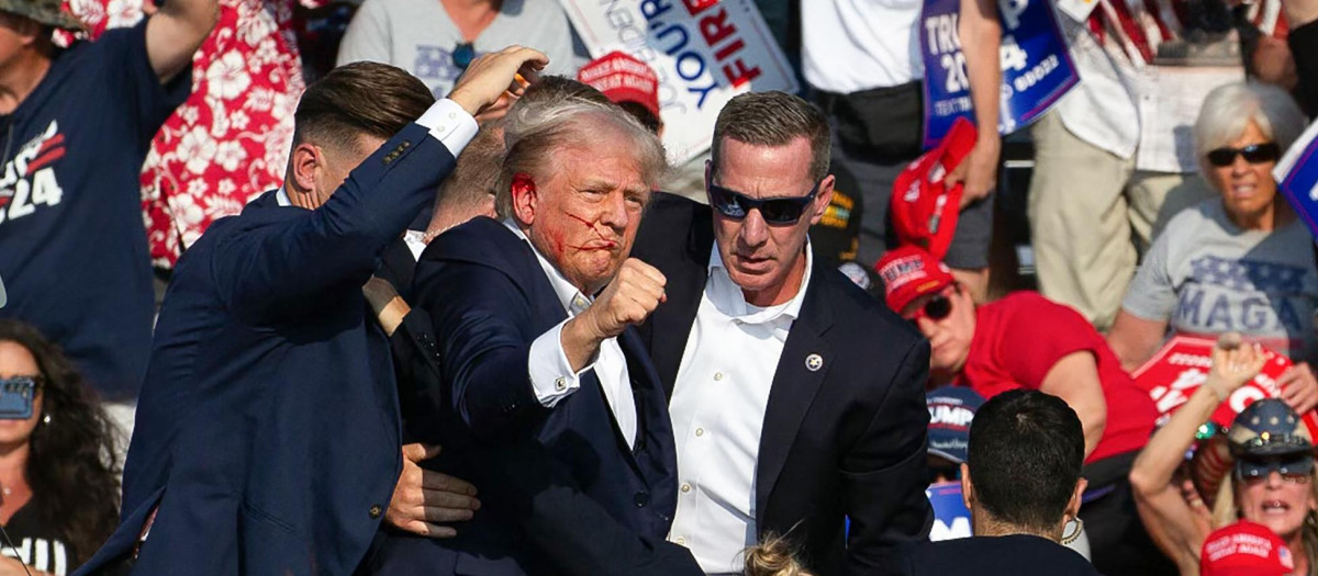El candidato republicano Donald Trump es visto con sangre en su rostro rodeado de agentes del servicio secreto, incluido Sean Curran