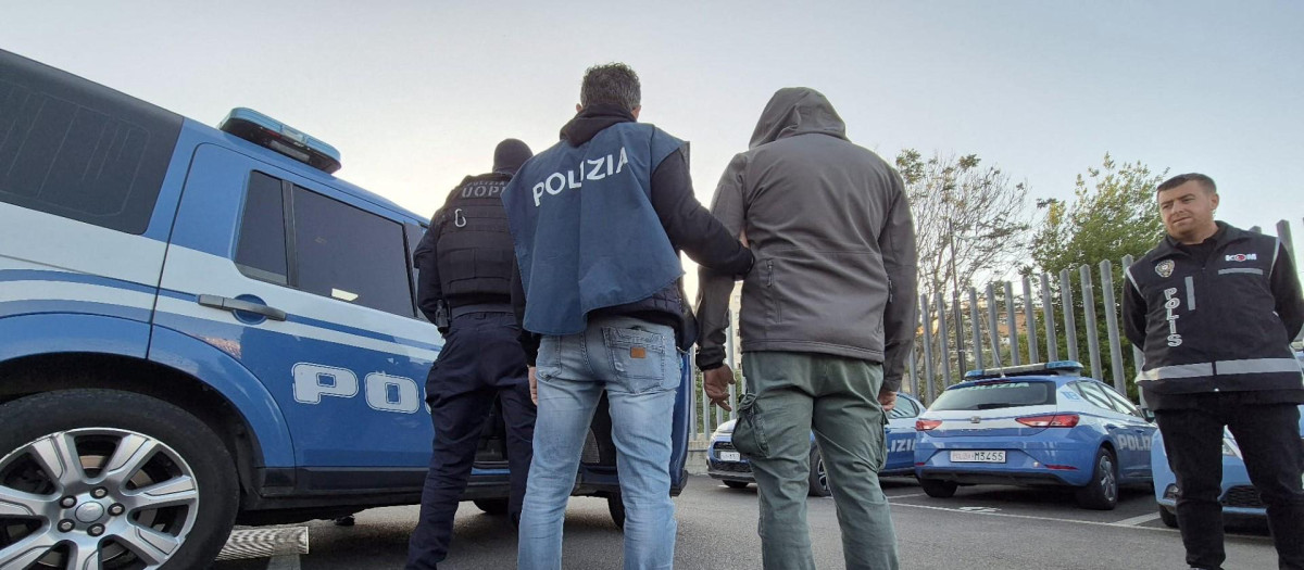 Agentes de policía italianos escoltando a un detenido