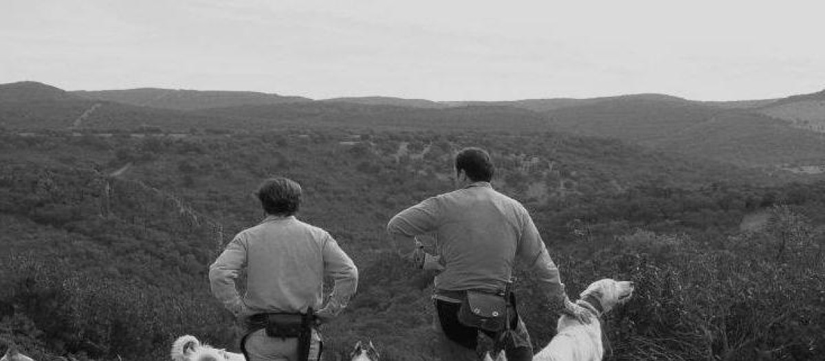 Dos cazadores junto a sus perros