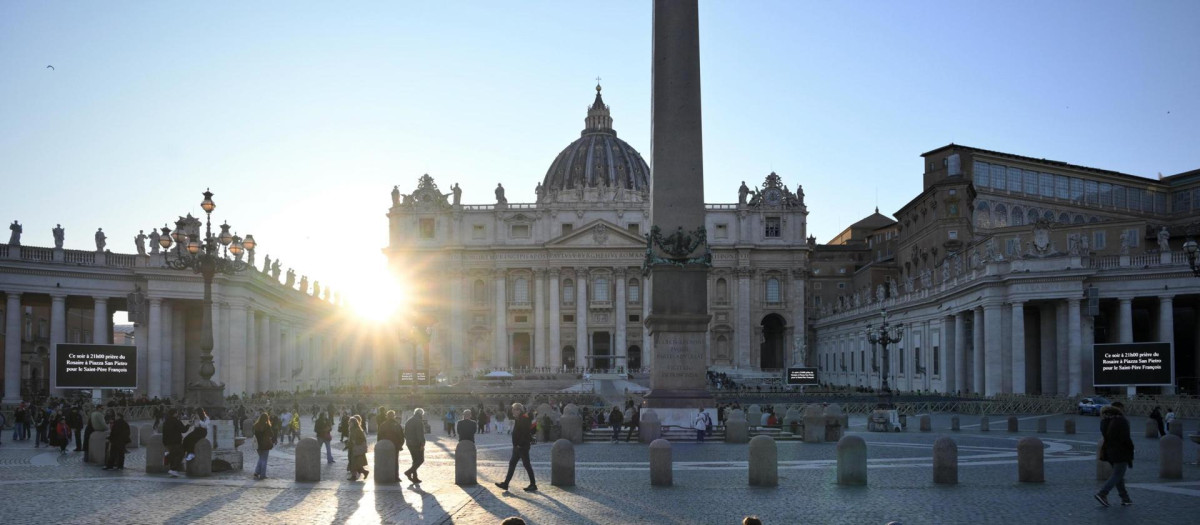 La gente se sienta cerca de la Basílica de San Pedro al atardecer en la Ciudad del Vaticano