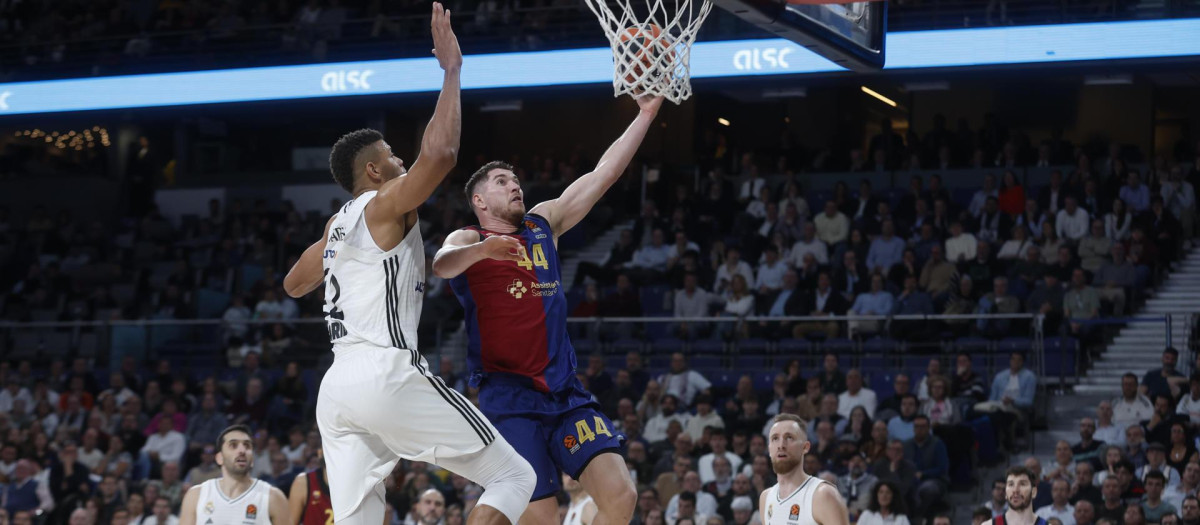 El alero del Barça Joel Parra (d) entra a canasta defendido por Edy Tavares, del Real Madrid