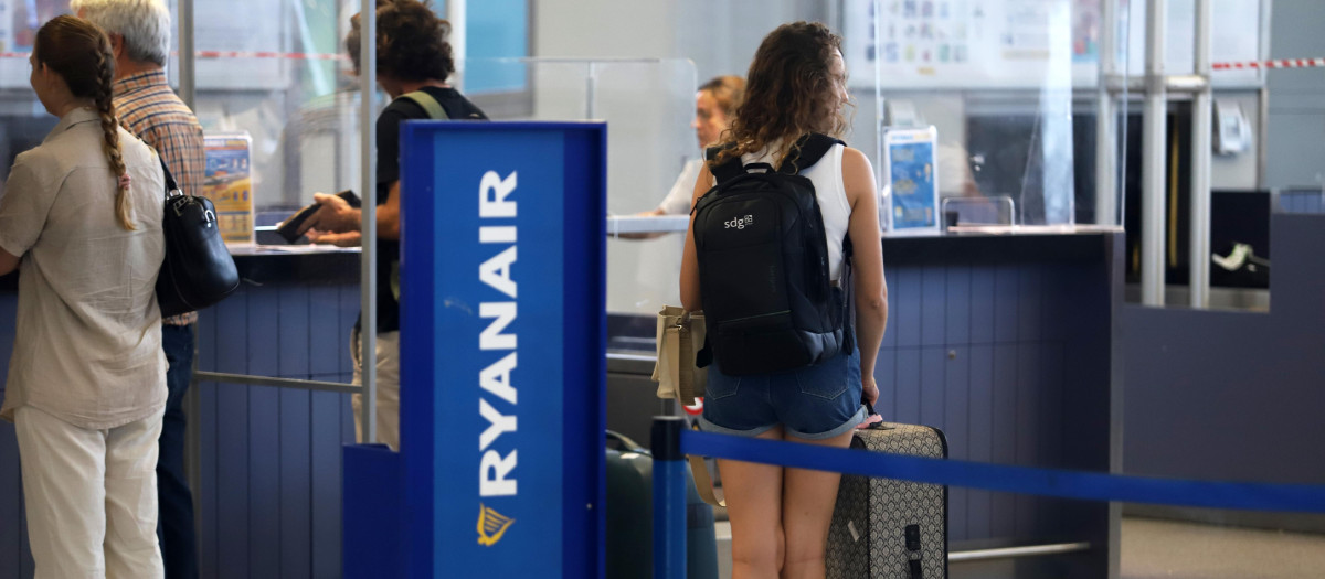 Turistas hacen colas en los puestos de embarque de Ryanair, en el Aeropuerto Costa del Sol, Málaga