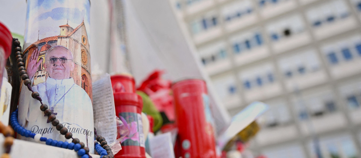 A candle with a portrait of Pope Francis is displayed at the statue of John Paul II outside the Gemelli Hospital where Pope Francis is hospitalized in Rome, on March 11, 2025. Pope Francis spent a quiet night in the hospital, the Vatican said on March 11, 2025, a day after it indicated for the first time that the 88-year-old pontiff could soon be discharged after spending more than three weeks being treated for double pneumonia. (Photo by Alberto PIZZOLI / AFP)Una vela con un retrato del Papa Francisco se muestra en la estatua de Juan Pablo II fuera del Hospital Gemelli donde el Papa Francisco está hospitalizado en Roma, el 11 de marzo de 2025. El Papa Francisco pasó una noche tranquila en el hospital, según informó el Vaticano el 11 de marzo de 2025, un día después de indicar por primera vez que el pontífice de 88 años podría recibir pronto el alta tras pasar más de tres semanas recibiendo tratamiento por una doble neumonía. (Foto de Alberto PIZZOLI / AFP)