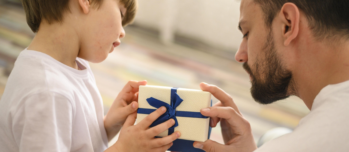 Un niño entrega un regalo a su padre