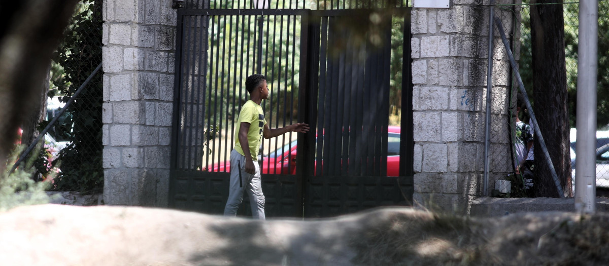 Un joven pasa por la puerta del centro de primera acogida de menores extranjeros no acompañados (menas) situado en la zona de Casa de Campo, en Madrid