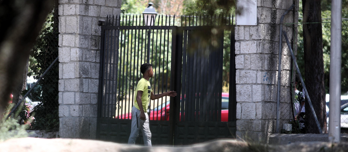 Un joven pasa por la puerta del centro de primera acogida de menores extranjeros no acompañados (menas) situado en la zona de Casa de Campo, en Madrid