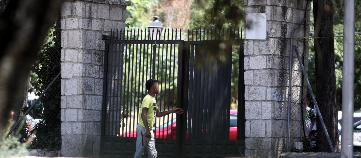 Un joven pasa por la puerta del centro de primera acogida de menores extranjeros no acompañados (menas) situado en la zona de Casa de Campo, en Madrid