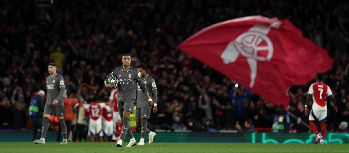 Kylian Mbappe lleva el balón al centro del campo mientras el Arsenal celebra un gol
