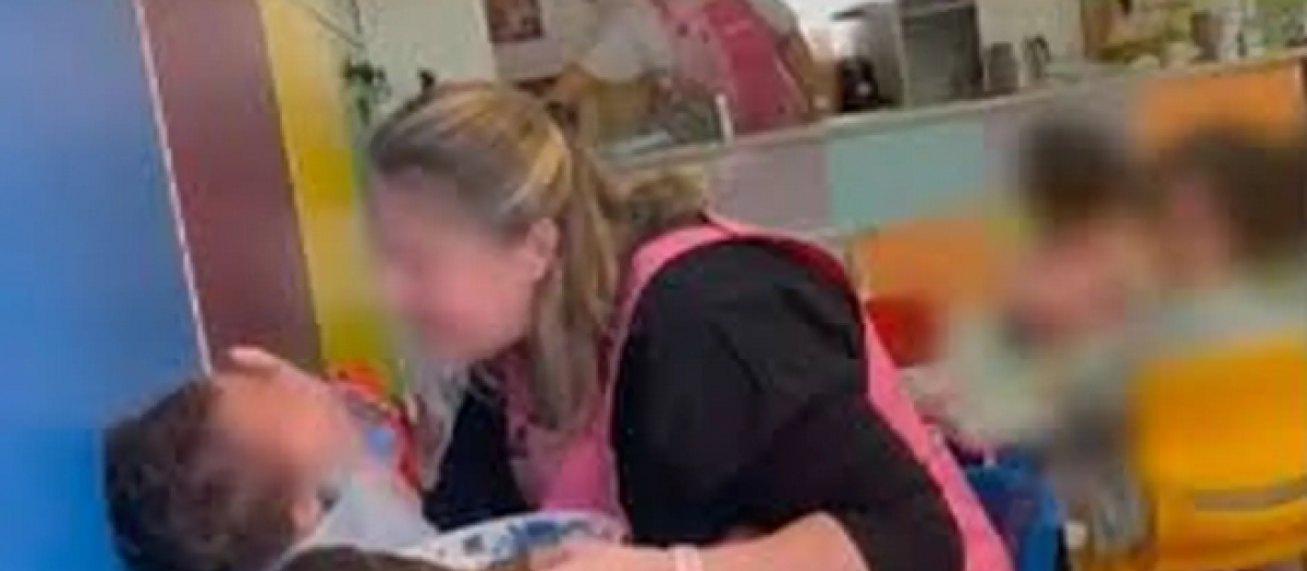 La cuidadora pegando a uno de los bebés