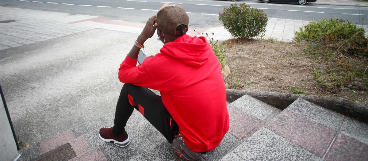Un inmigrante sentado en la calle, a 20 de septiembre de 2024, en Monterroso, Lugo, Galicia (España)