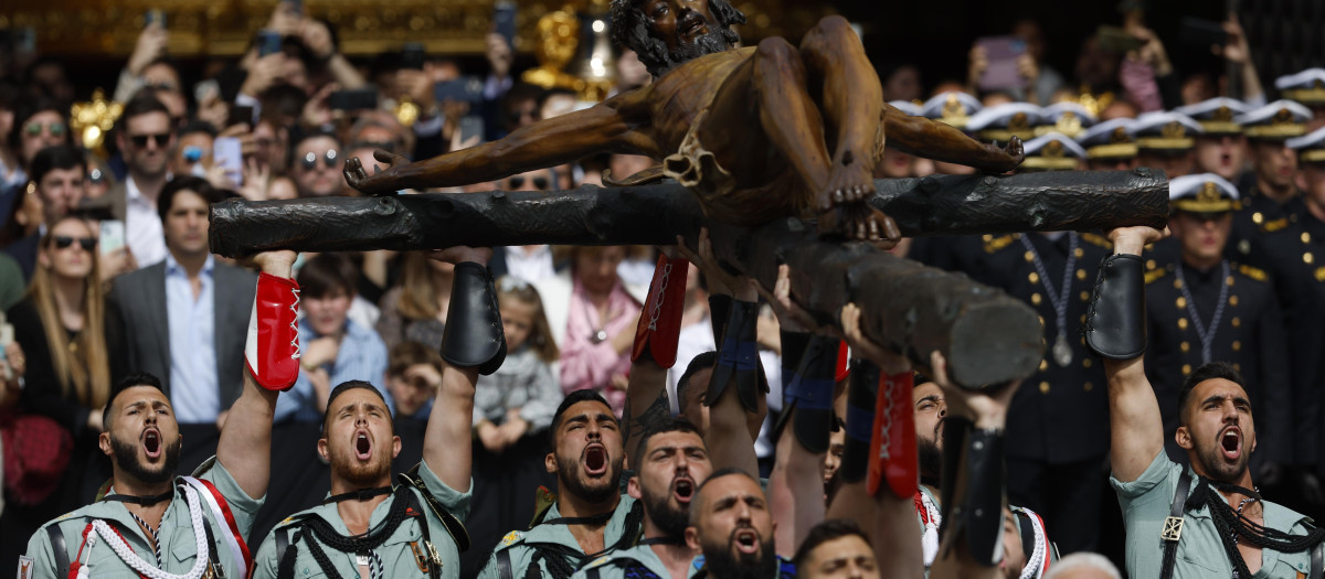 Miembros de la Legión portan el Cristo de la Buena Muerte, de la Cofradía de Mena, por las calles de Málaga