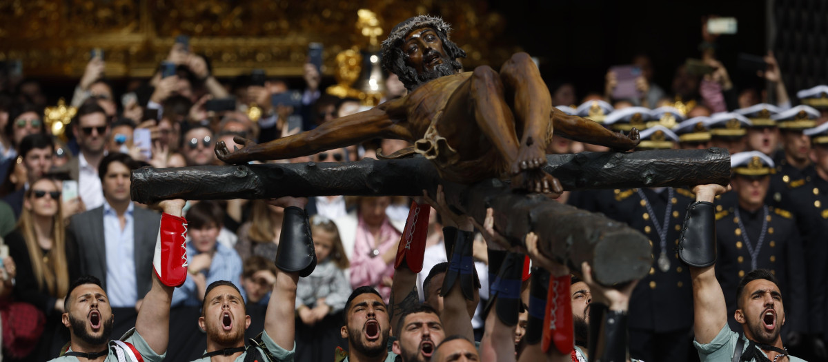 Miembros de la Legión portan el Cristo de la Buena Muerte, de la Cofradía de Mena, por las calles de Málaga