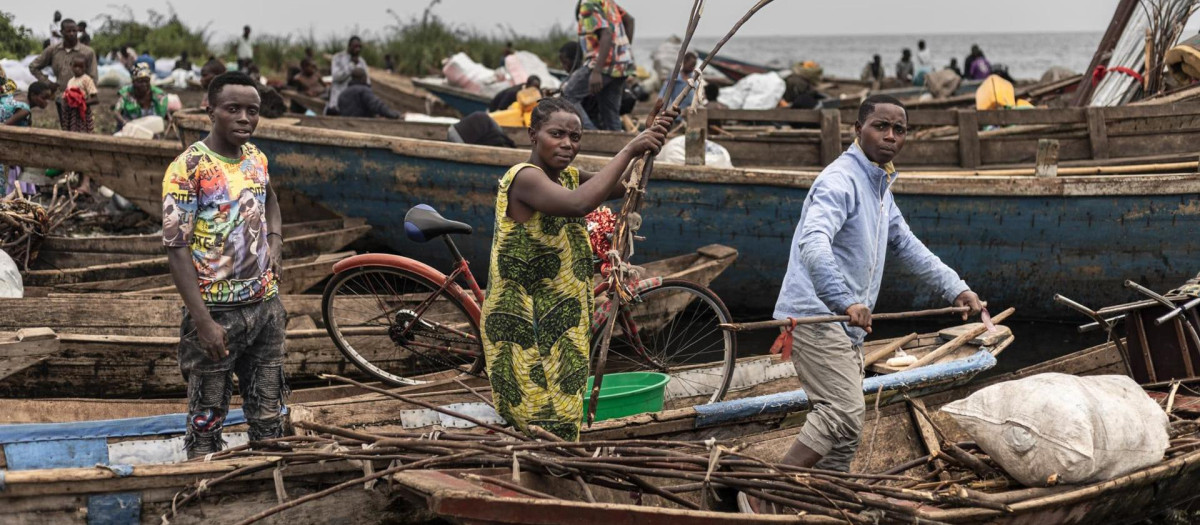 Personas cargan sus pertenencias en una embarcación al abandonar el campamento en Bulengo, República Democrática del Congo