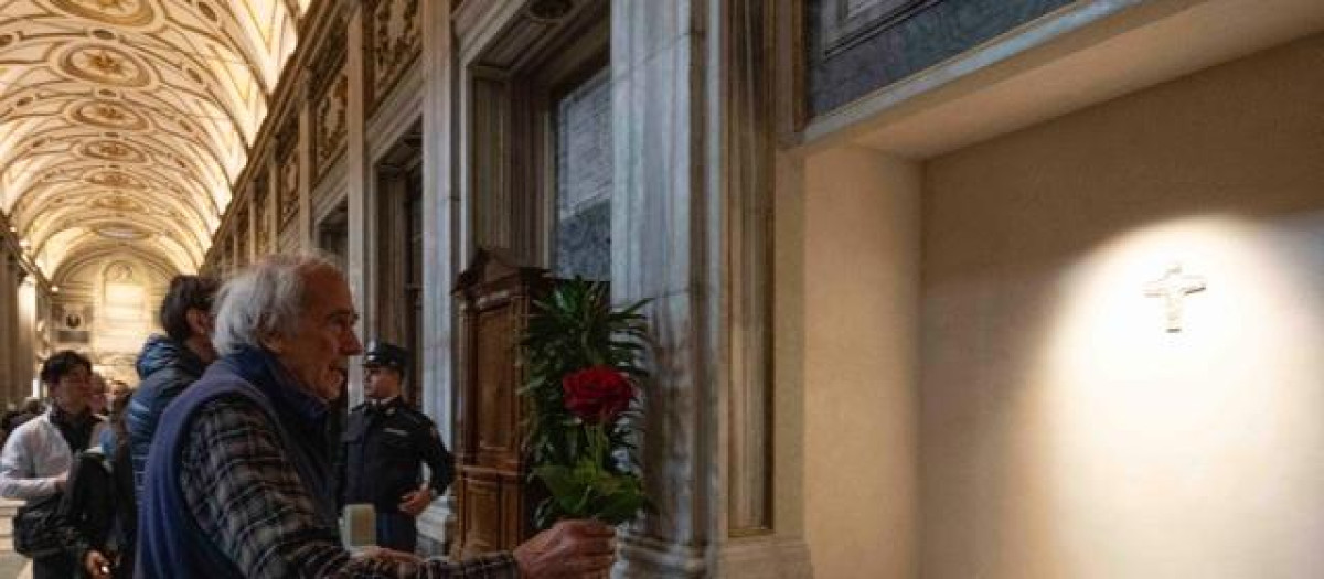 Un hombre lleva una rosa a la tumba del Papa Francisco en la basílica de Santa María la Mayor