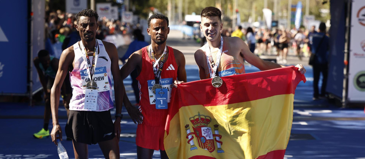 El etíope Derara Urisa (c) vencedor de la maratón de Madrid este domingo posa junto a su compatriota Limenih Getachew (i), segundo y el español Yago Rojo (d) tercero
