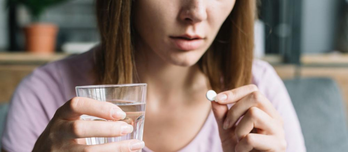 Mujer tomando una pastilla