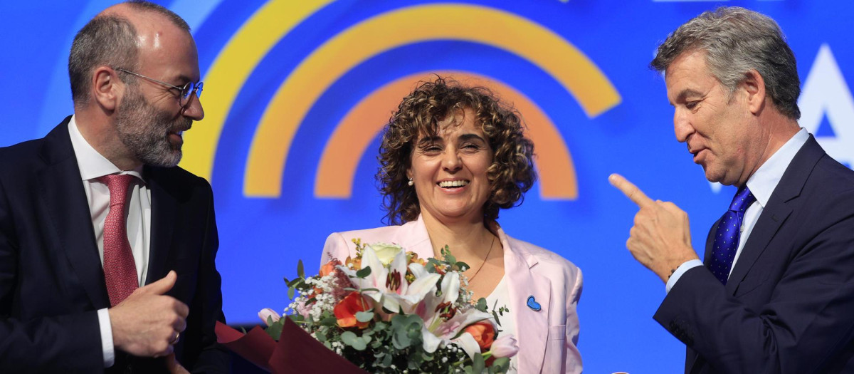 La eurodiputada y secretaria general del PPE Dolors Monserrat con un ramo de flores junto al presidente del Partido Popular Europeo, Manfred Weber (i), y el presidente del Partido Popular, Alberto Núñez Feijóo, tras su confirmación como secretaria general en el marco de la segunda jornada del congreso del Partido Popular Europeo en Valencia