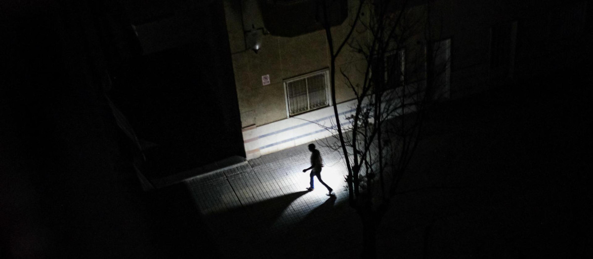 Un vecino de Elche camina con una linterna durante el apagón eléctrico.
