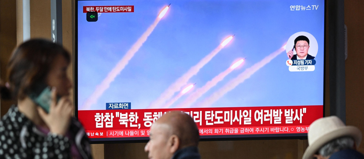 Personas observan una pantalla de televisión que muestra un noticiero con imágenes de archivo de una prueba de misil norcoreano