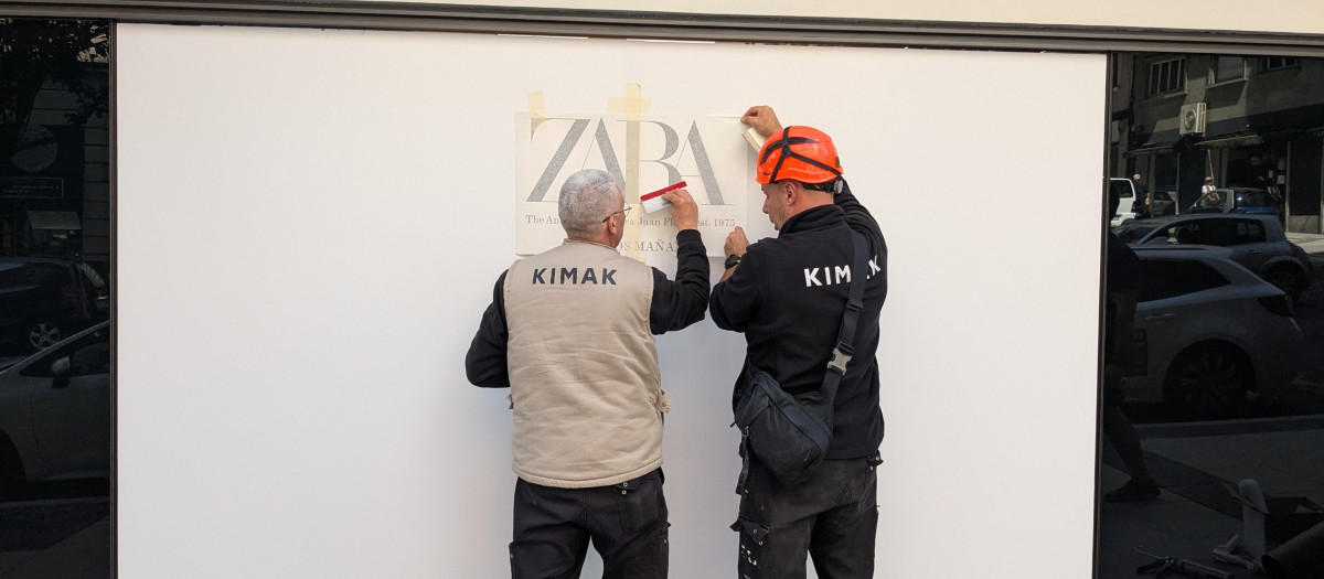 Operarios trabajan en el escaparate del primer Zara que abrió en el mundo, ubicado en la calle Juan Flórez de La Coruña