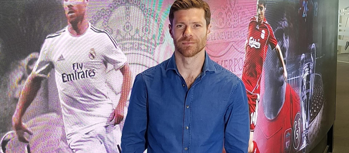 Xabi Alonso posa ante dos fotos suyas jugando para Real Madrid y Liverpool