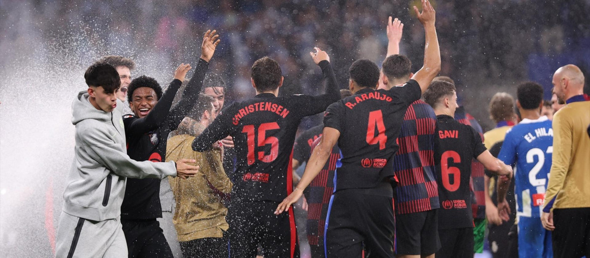 Los jugadores del Barça celebran el título liguero mientras saltan los aspersores