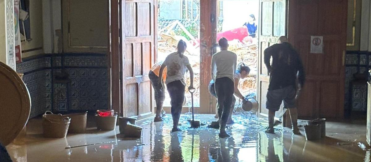 Voluntarios achicando agua en la parroquia