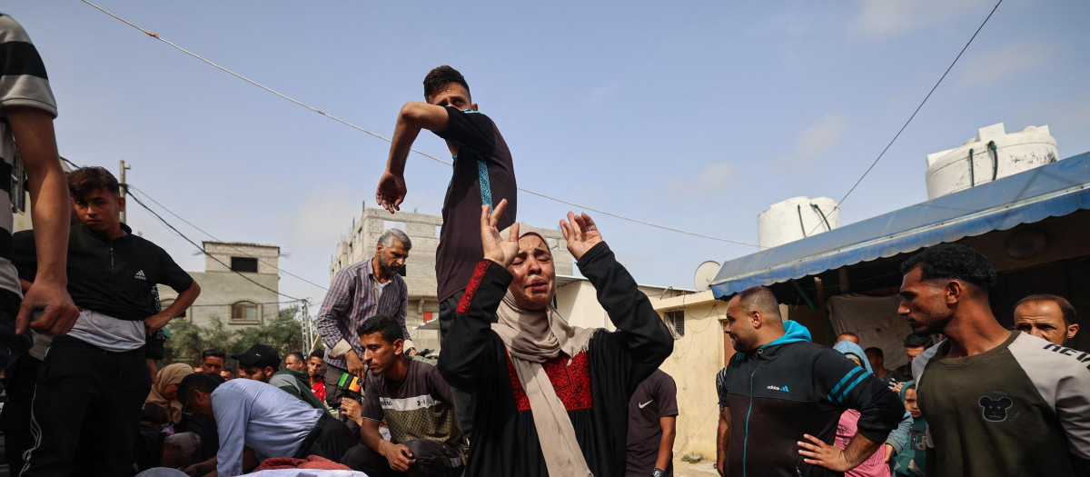 Palestinos lloran junto a los cuerpos de sus familiares fallecidos en ataques israelíes, en el Hospital de los Mártires de Al-Aqsa en Deir el-Balah, en el centro de la Franja de Gaza