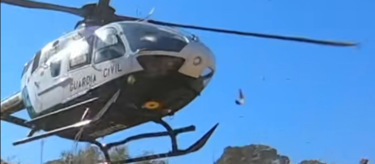 El helicóptero de la Guardia Civil tomando tierra junto a los moteros