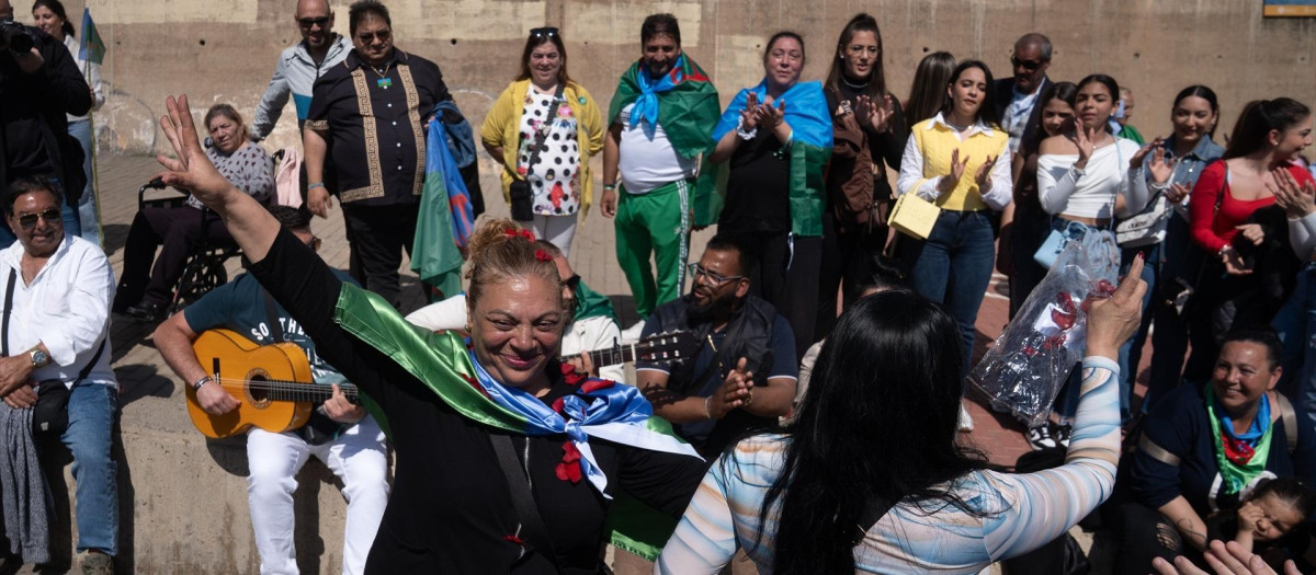 Varias personas bailan y cantan durante la ceremonia del río, en el Pont de Cristòfol Moura