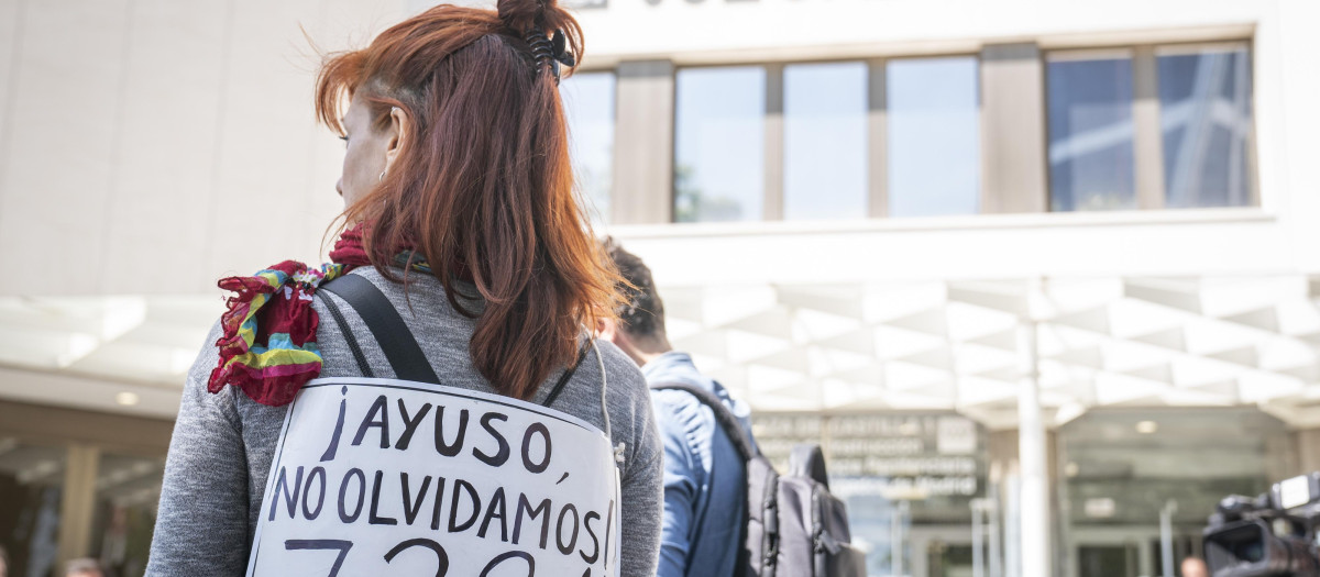 Una joven se manifiesta a las puertas del Juzgado de Plaza Castilla contra la gestión de Ayuso en las residencias durante el covid