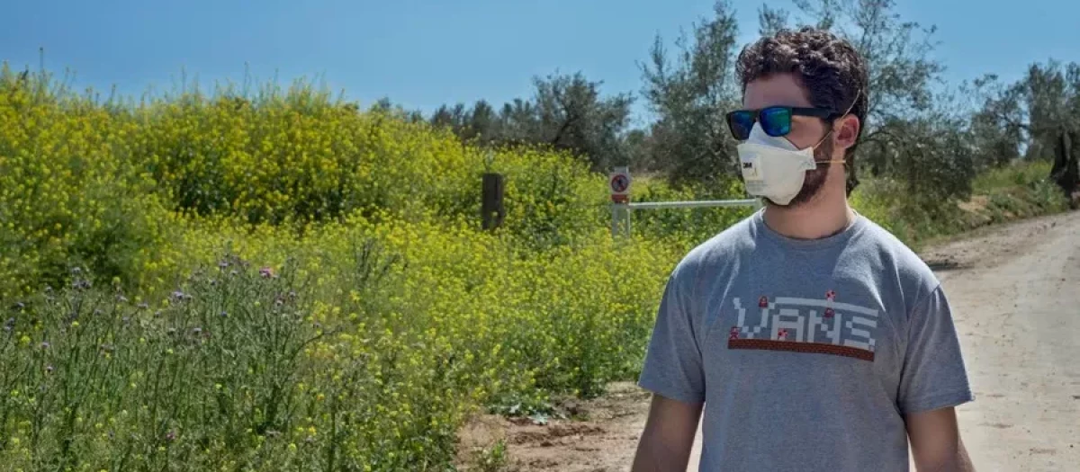 Un joven se protege en las afueras de Jaén, debido a los altos niveles de granos de polen de olivo, en una imagen de archivo