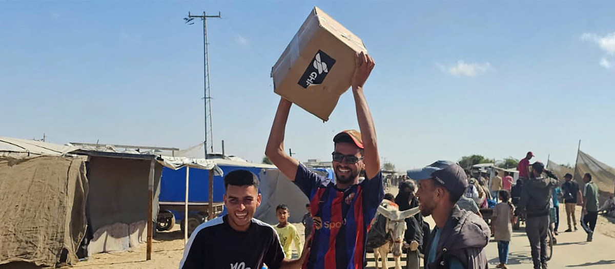 Palestinos desplazados reciben paquetes de alimentos de una fundación respaldada por Estados Unidos que se compromete a distribuir ayuda humanitaria en el oeste de Rafah, en el sur de la Franja de Gaza