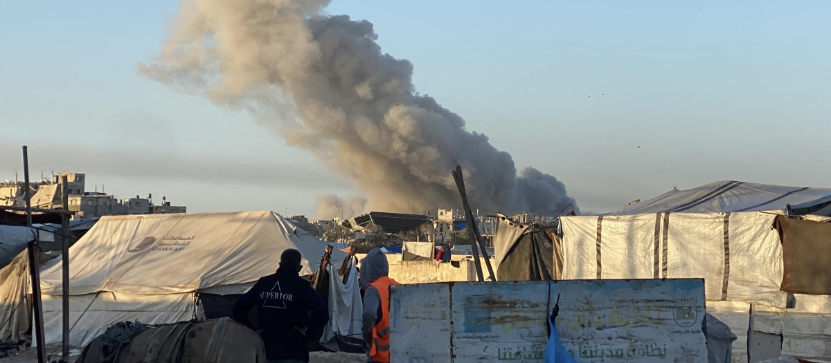 El humo de un ataque israelí se eleva al fondo, como se ve en la imagen desde un campamento de desplazados palestinos en Rafah, al sur de la Franja de Gaza