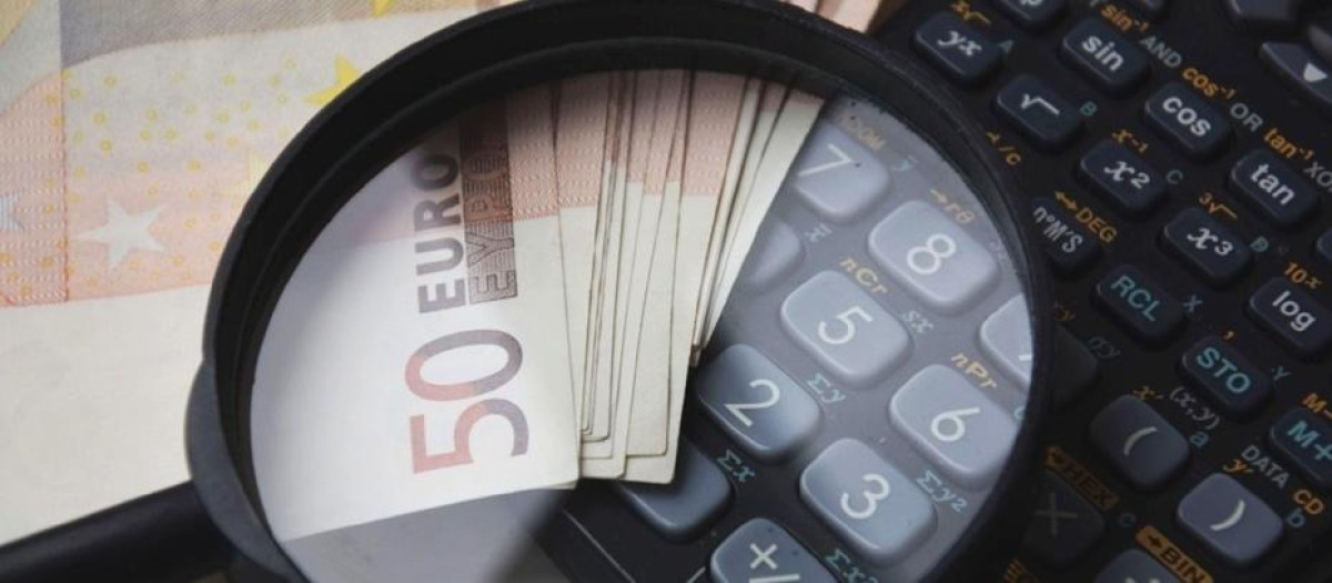 Billetes y calculadora ilustran la emisión de deuda en Andalucía.