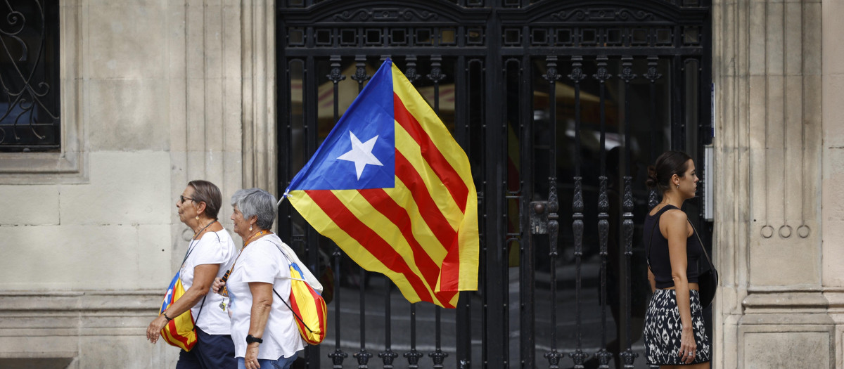 Imagen de dos mujeres con una estelada tomada durante una manifestación