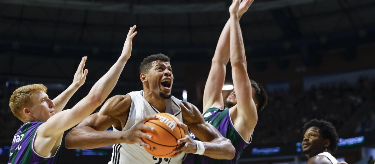 Los jugadores del Unicaja y el Madrid luchan por una bola