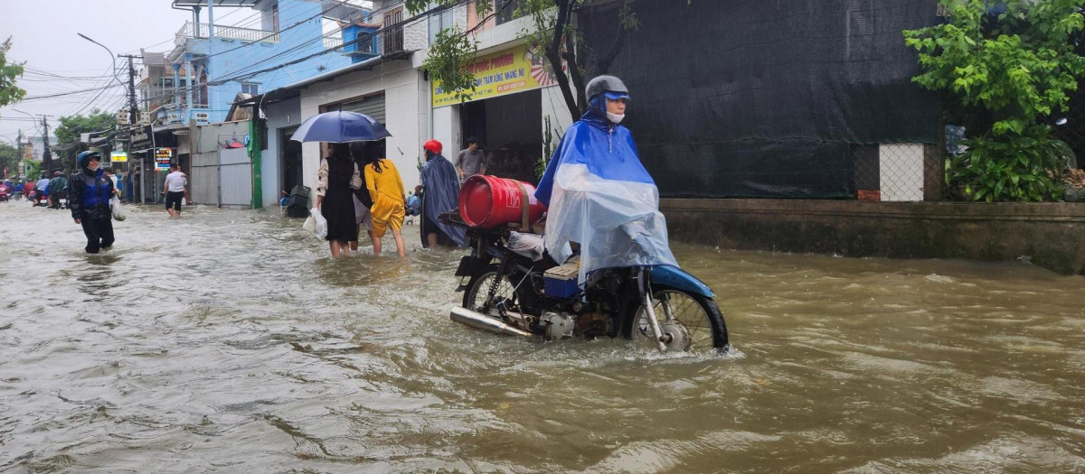 Personas caminan en medio de las inundaciones de Vietnam