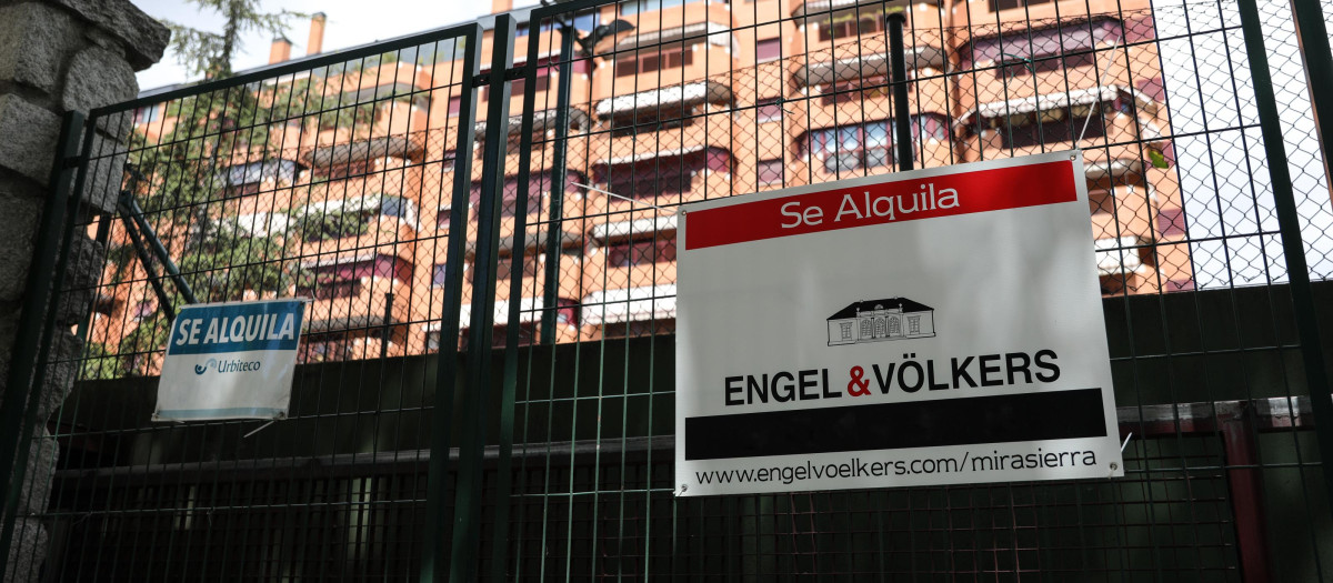En la valla de una urbanización, se ven colgados dos carteles de 'Se alquila'
