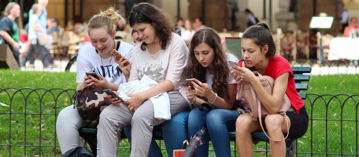 Varias chicas consultando sus teléfonos móviles
