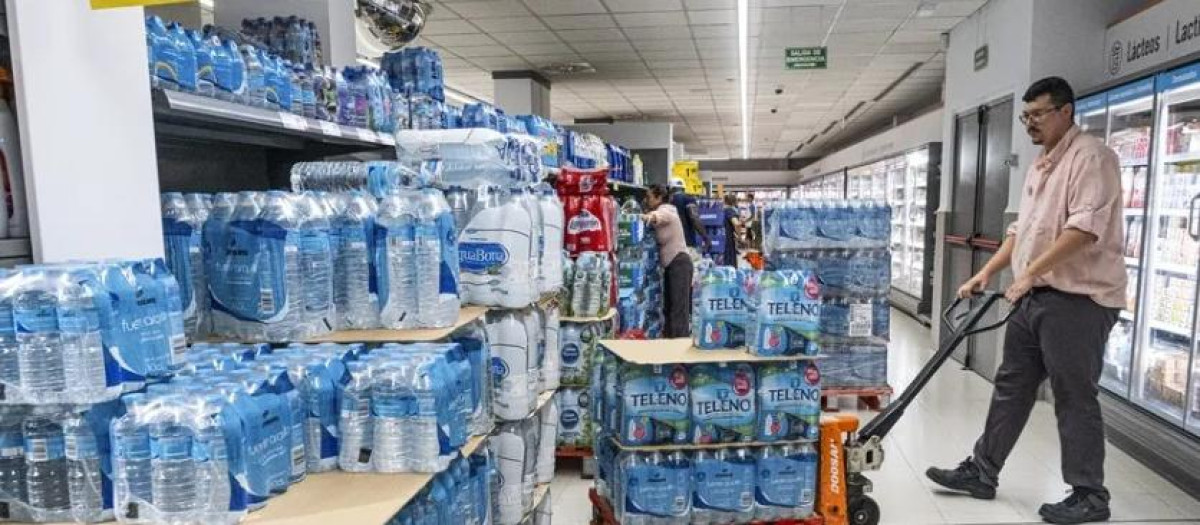 Un reponedor transporta agua en un supermercado, en una imagen de archivo