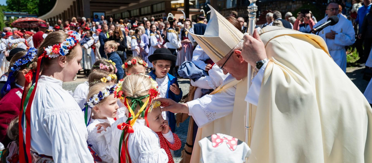 Monseñor Josef Nuzík saluda a unos niños tras una misa
